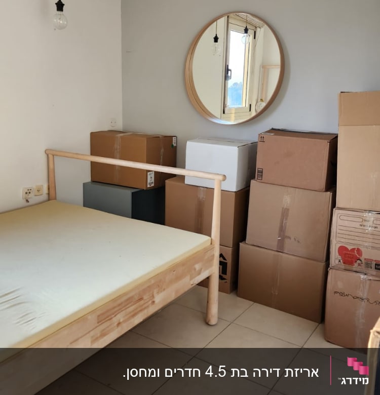 חדר עם מיטה מעץ וארגזים מסודרים בפינה